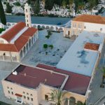 Stunning aerial view of a church with red roof in an urban setting surrounded by greenery.