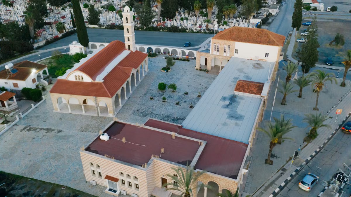 Stunning aerial view of a church with red roof in an urban setting surrounded by greenery.